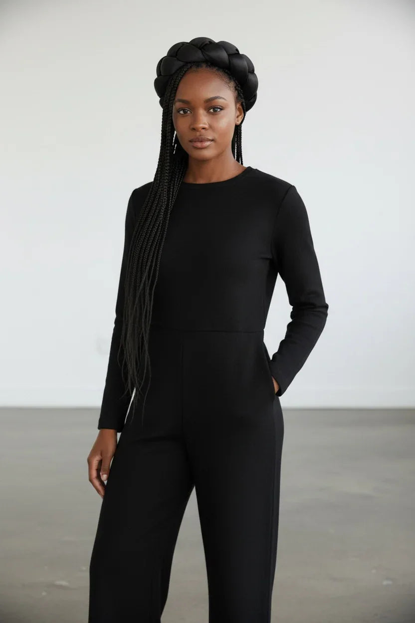 Person wearing a black long-sleeve top and pants against a white background