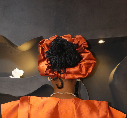 Woman wearing an orange satin ruffled headband